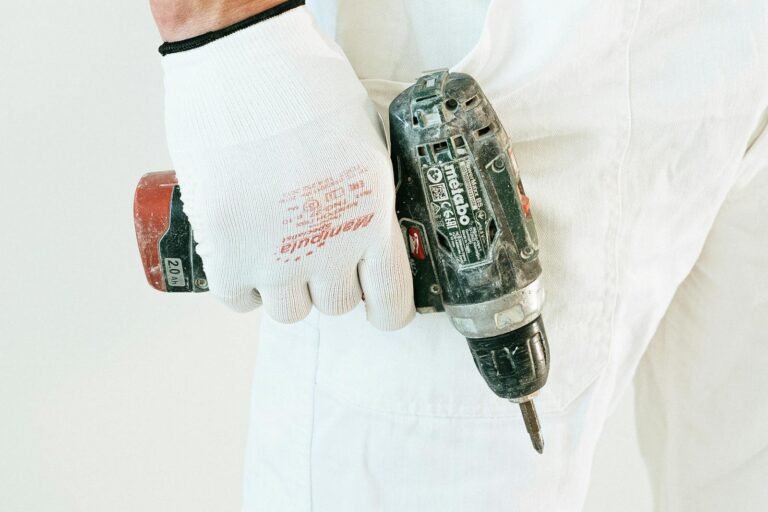 Hand schroeft in witte muur