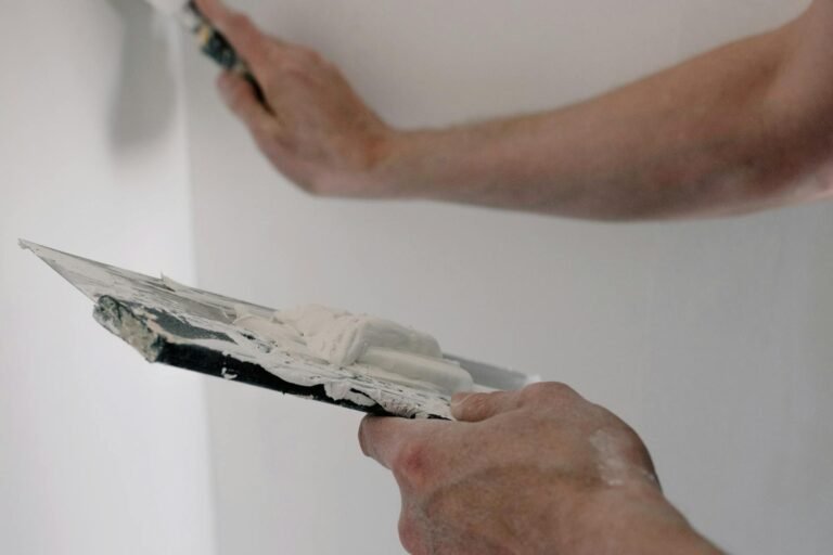 Man werkt met stopverf op muur