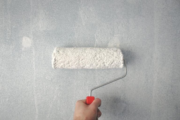 Persoon rolt verf op muur