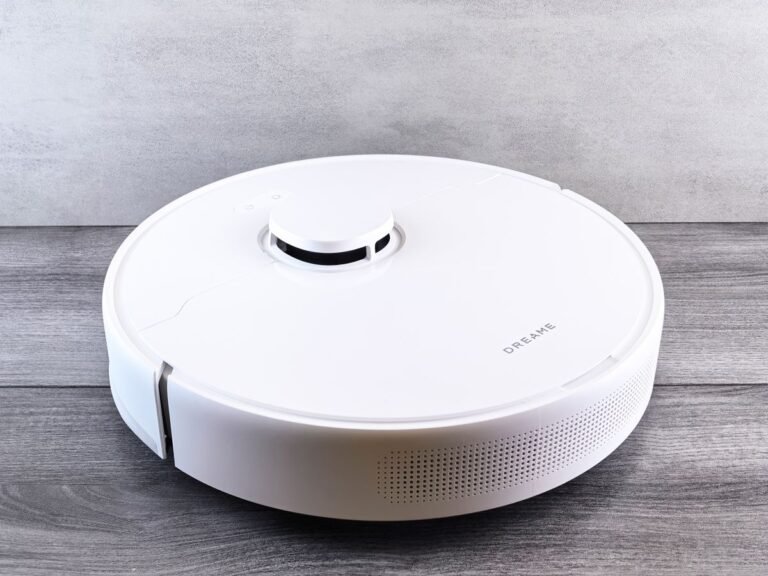 Witte robotstofzuiger rijdt over een houten vloer